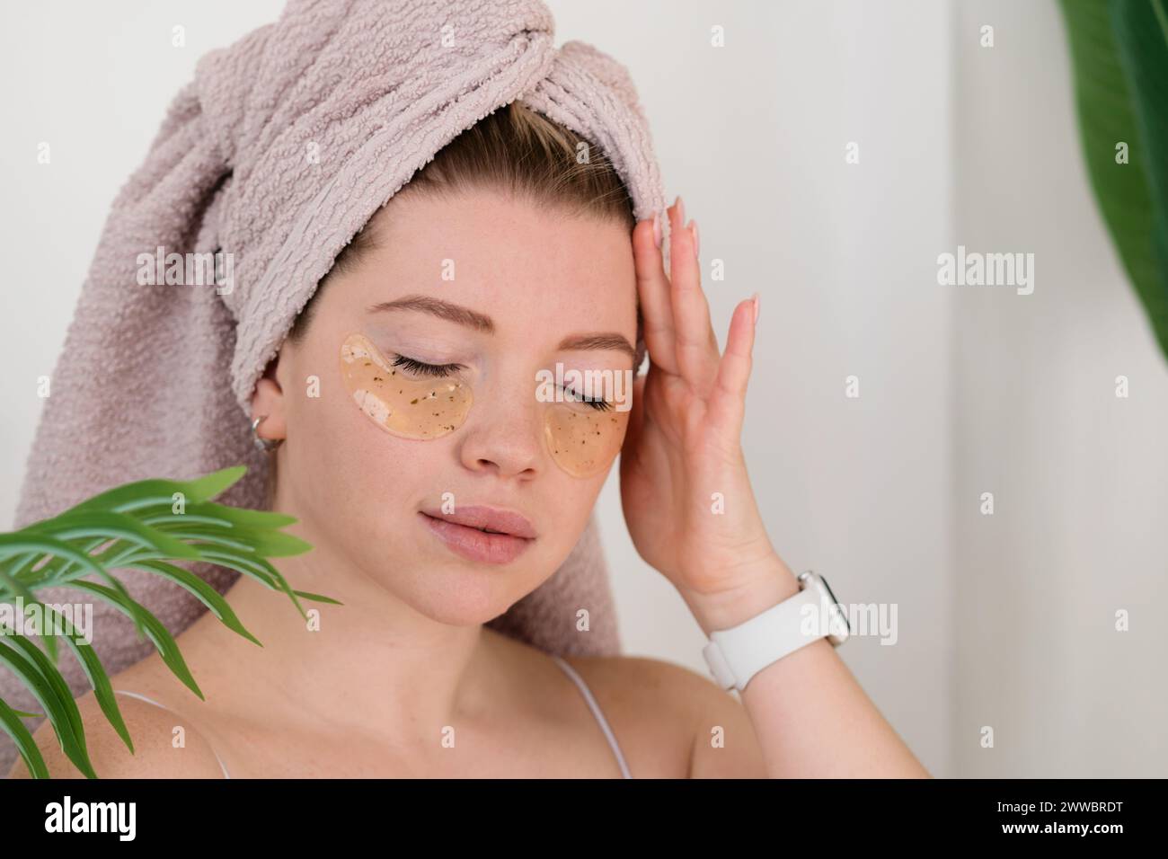 Woman applying eye hydrogel patches under eyes to remove puffiness. Skincare routine. Stock Photo