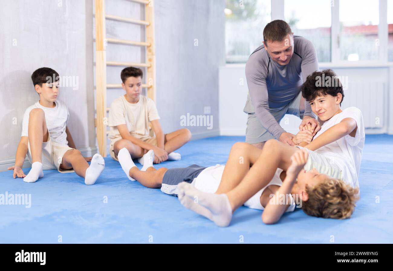 Two young boys training joint lock movement during group karate