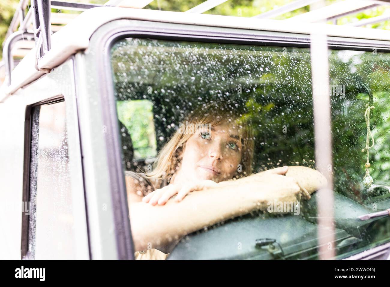 Woman sitting and looking through car window Stock Photo