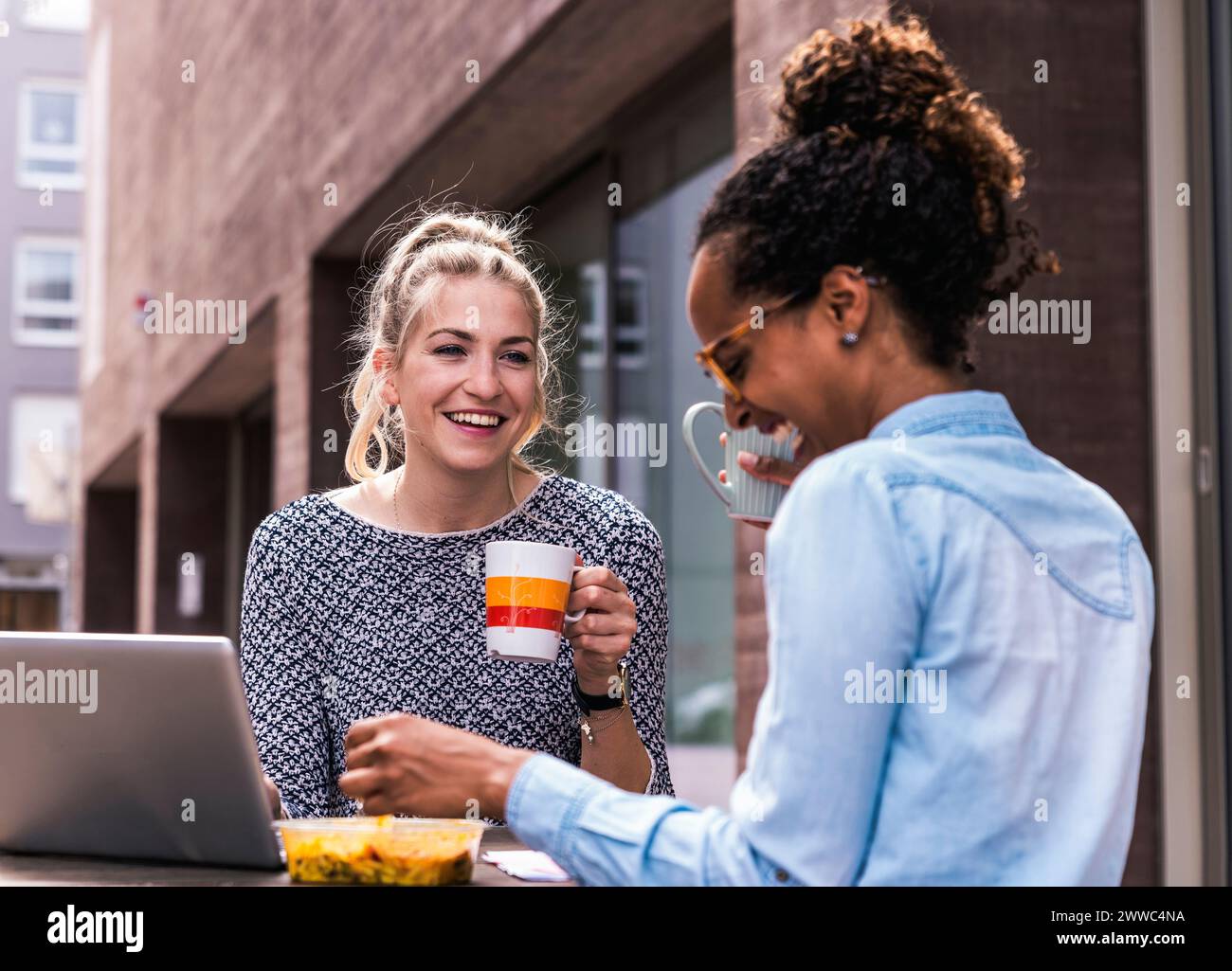 Happy coworkers taking a break near building Stock Photo - Alamy