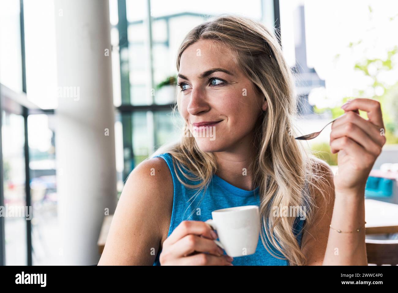 Smiling woman holding coffee cup in restaurant Stock Photo