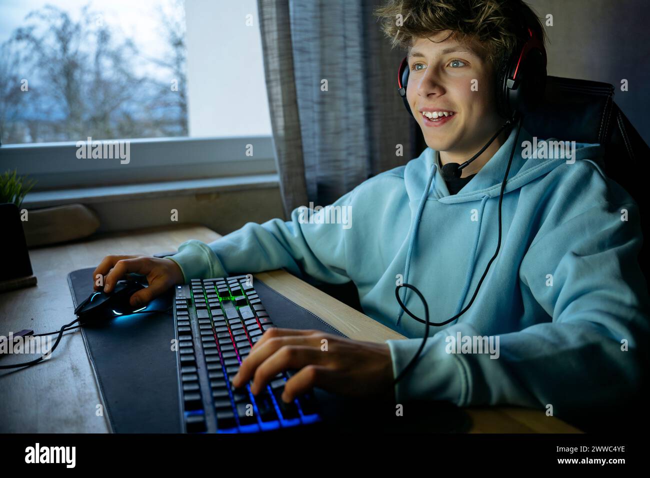 Happy boy playing game on computer through keyboard at home Stock Photo