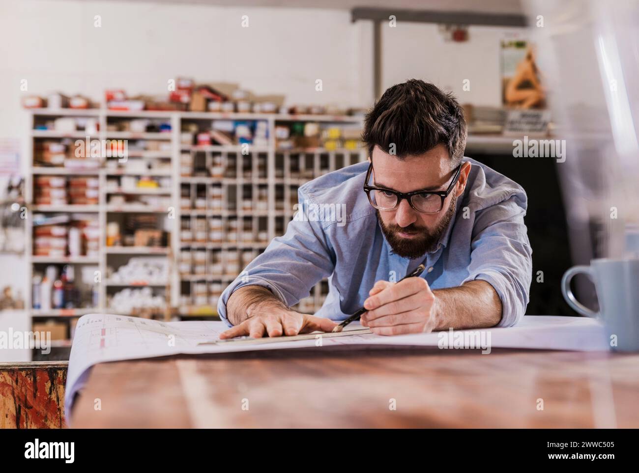 Focused young craftsman making blueprint at workshop Stock Photo - Alamy