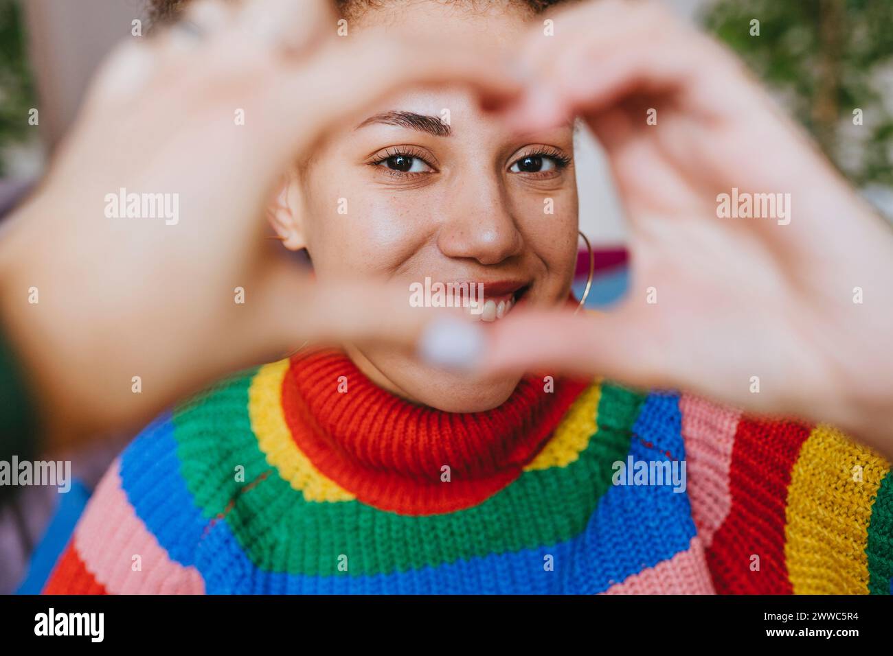 Smiling woman gesturing heart shape Stock Photo