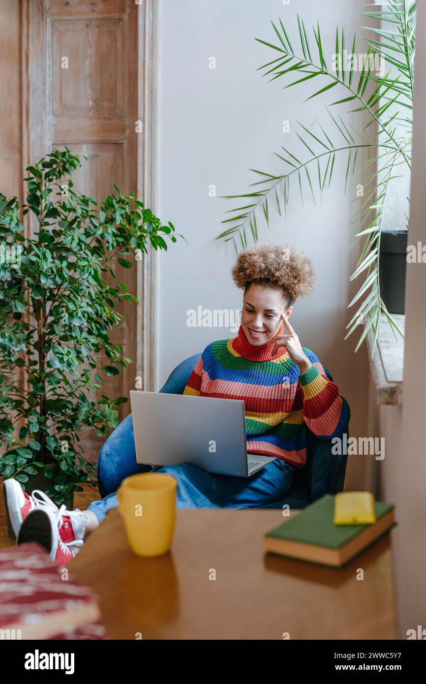 Smiling freelancer working on laptop at home Stock Photo