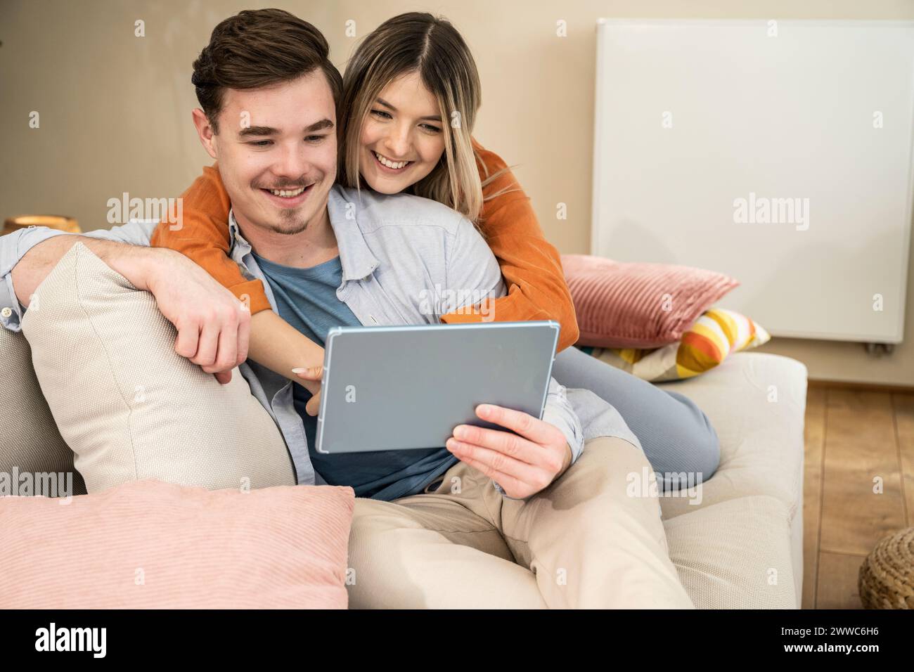 Happy couple using tablet PC at home Stock Photo