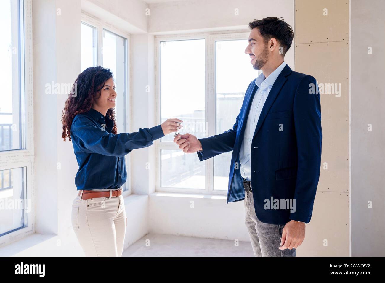 Real estate agent giving key to new owner of house Stock Photo - Alamy