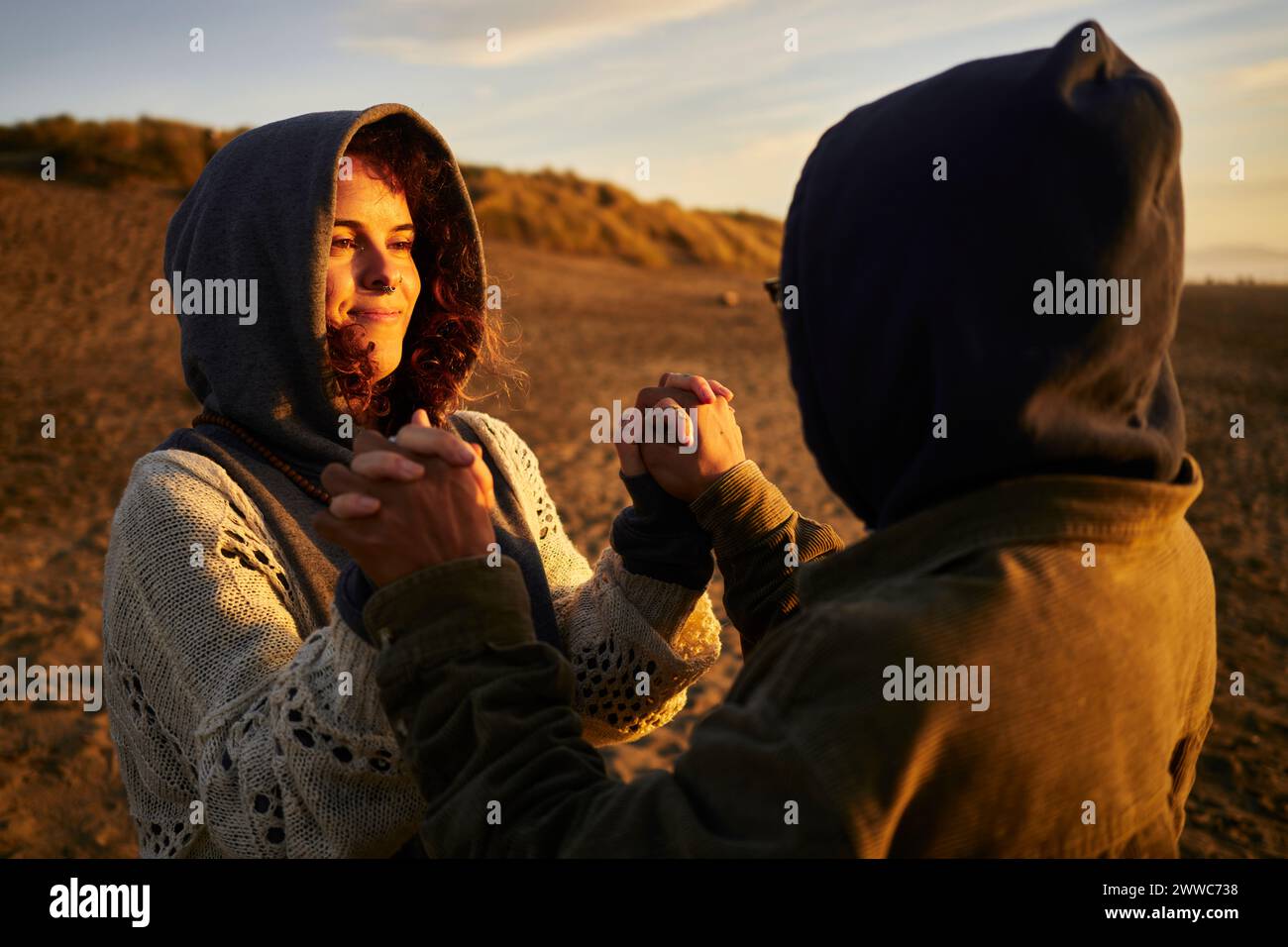 Happy couple holding hands and standing at beach Stock Photo - Alamy