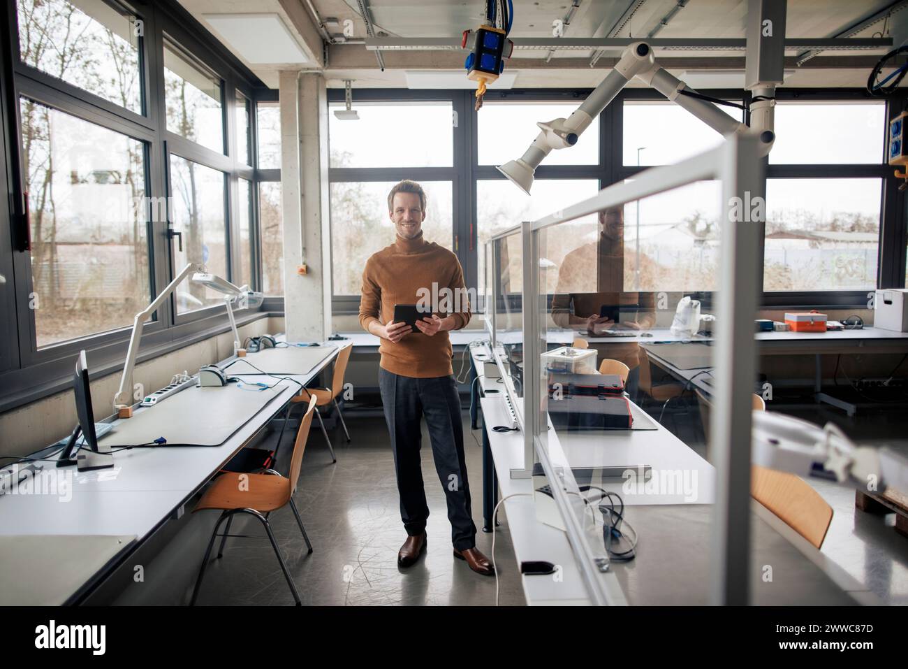Smiling engineer holding tablet PC at workshop Stock Photo