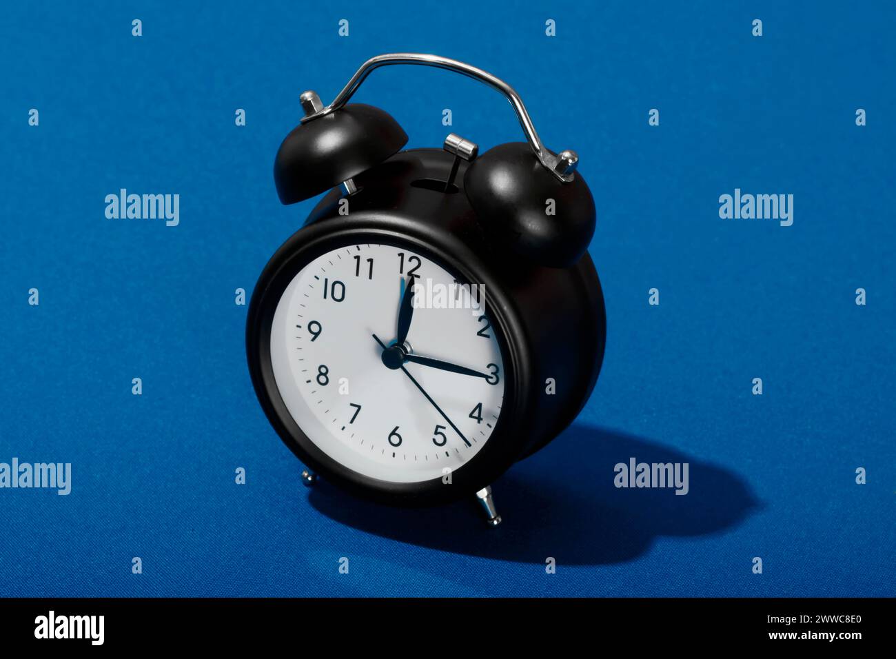 Retro style alarm clock on blue background Stock Photo