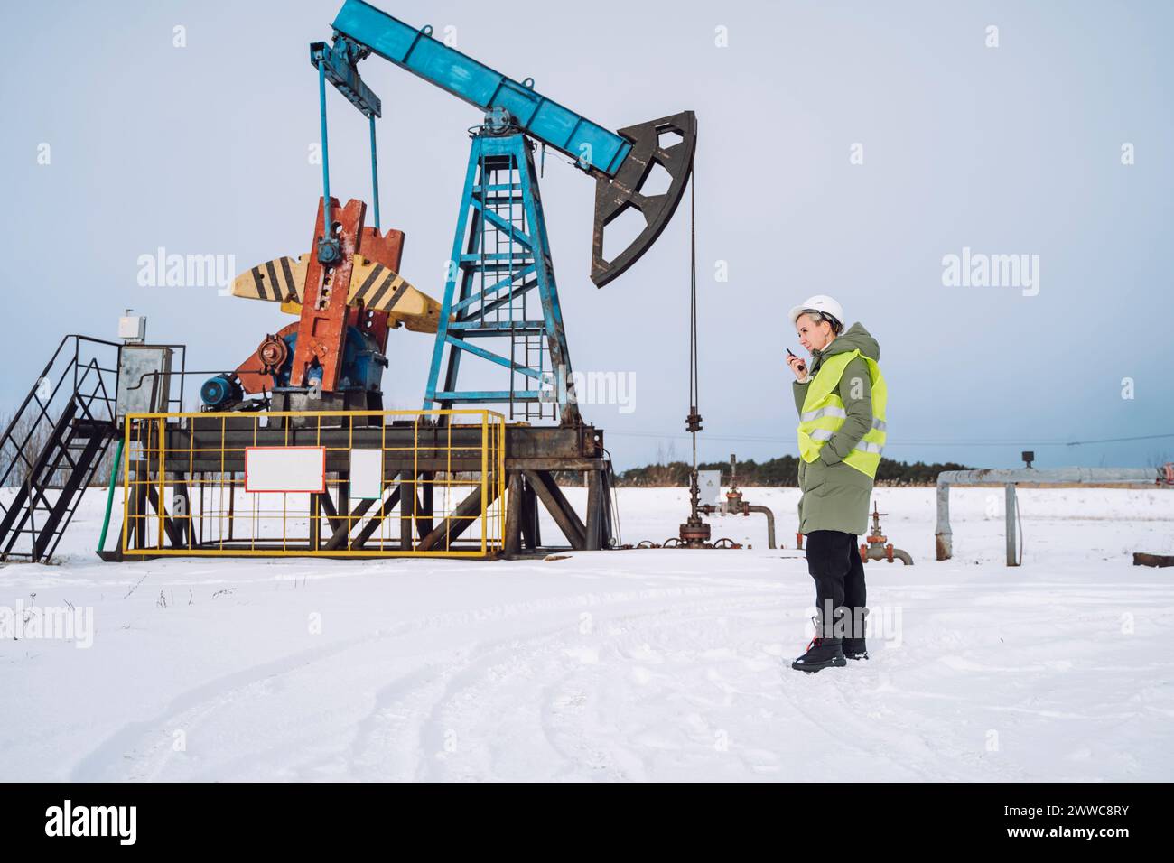 Engineer talking on walkie-talkie at oil field in winter Stock Photo