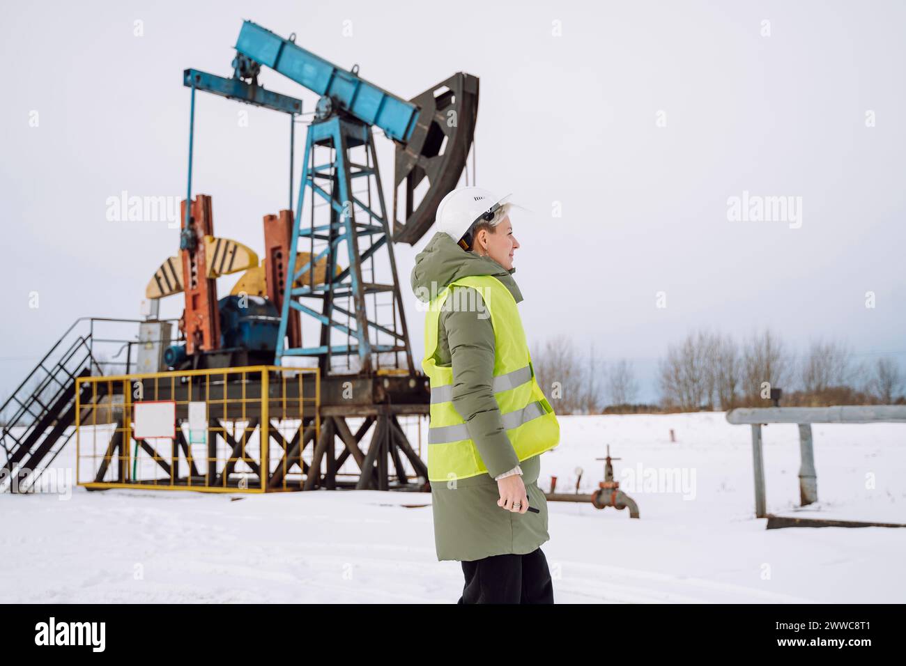 Engineer standing at oil production field in winter Stock Photo