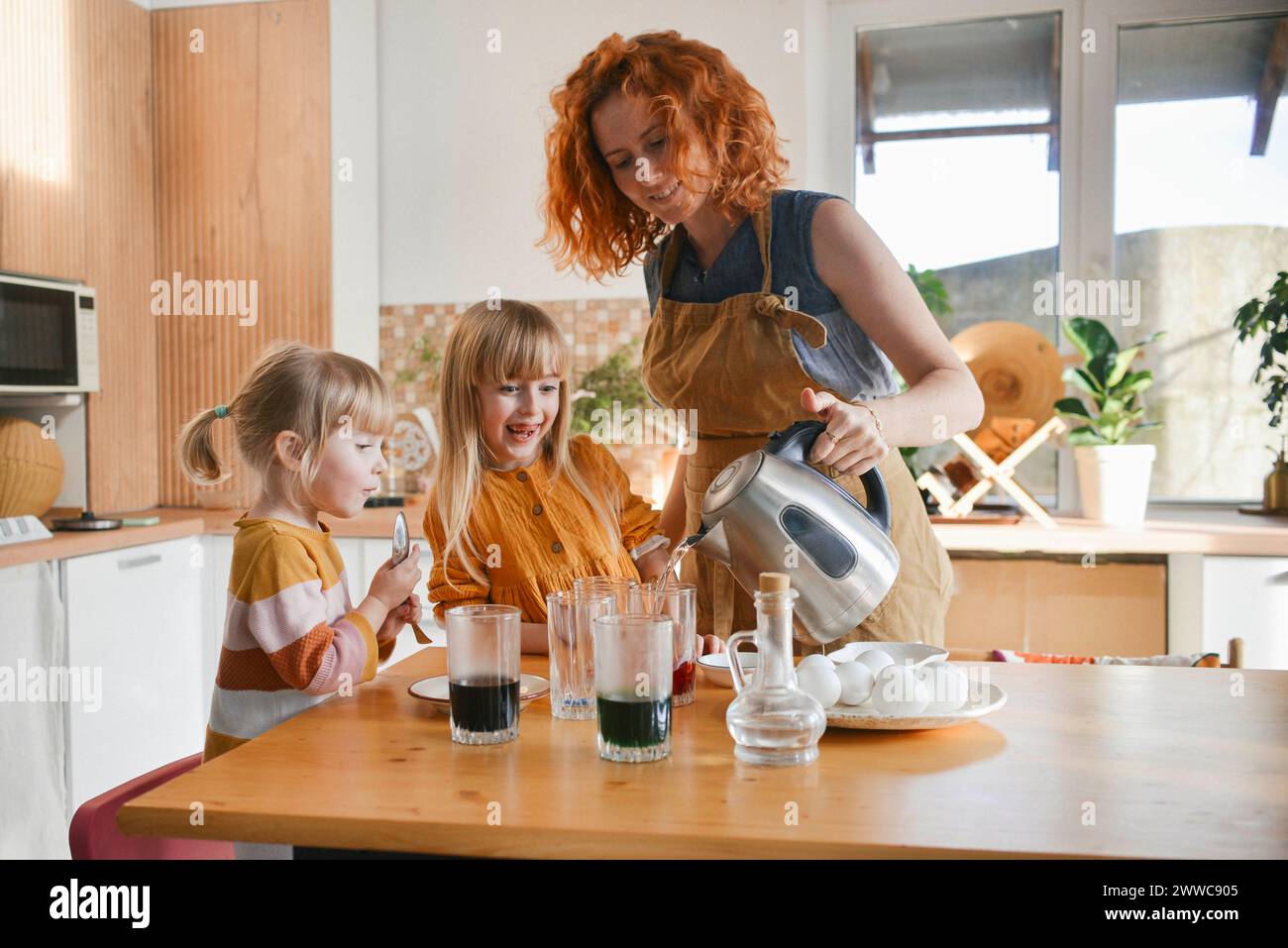 Mother preparing dye to paint Easter eggs at home Stock Photo