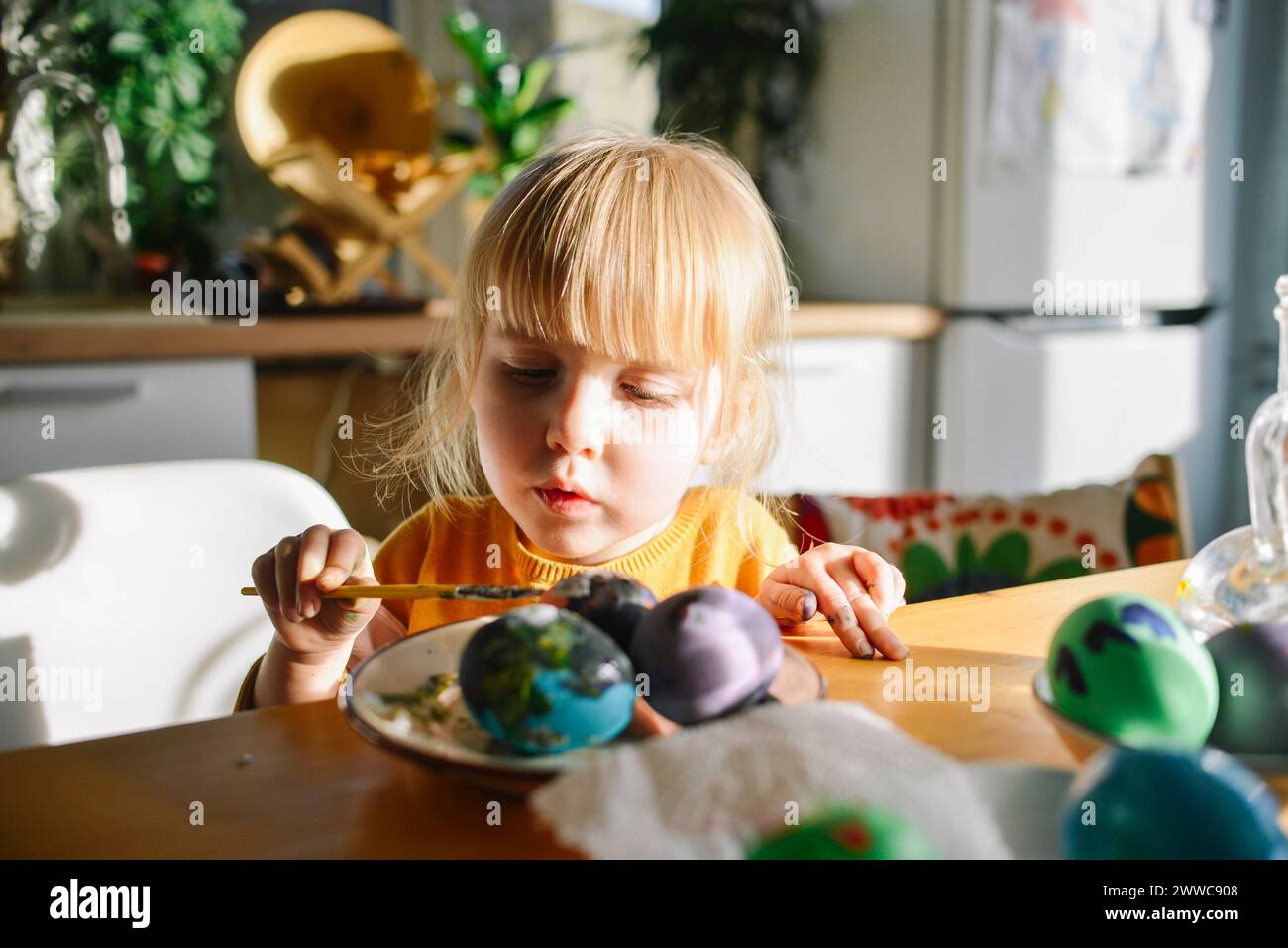 Girl with bangs coloring easter eggs at home stock photo alamy