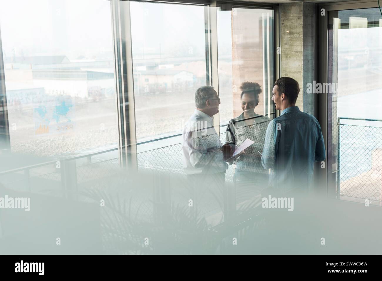Multiracial business colleagues discussing in workplace Stock Photo - Alamy
