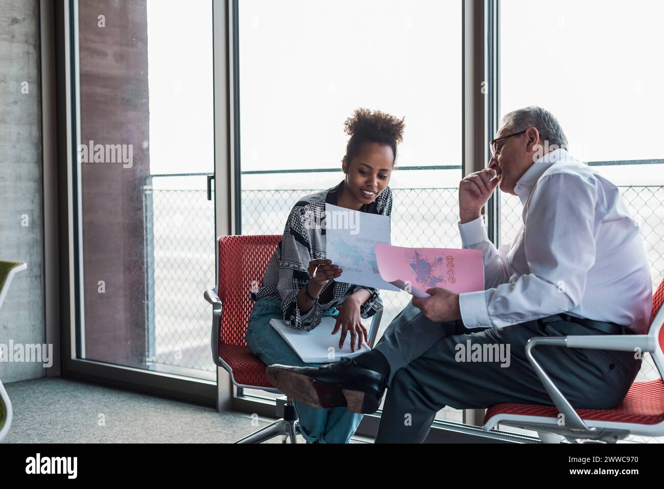 Multiracial business colleagues discussing over documents at workplace Stock Photo