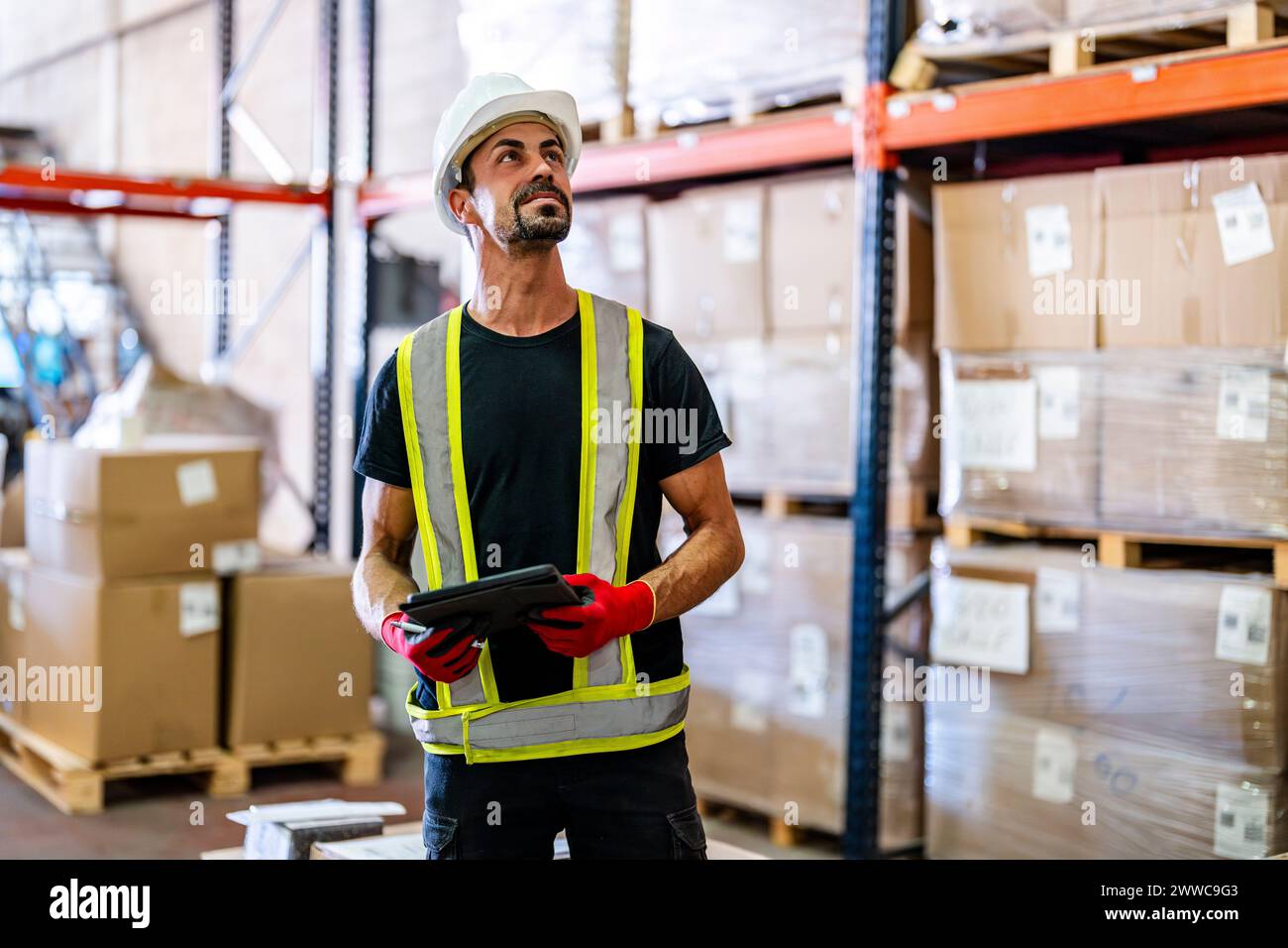 Smiling worker examining inventory with tablet PC at warehouse Stock Photo