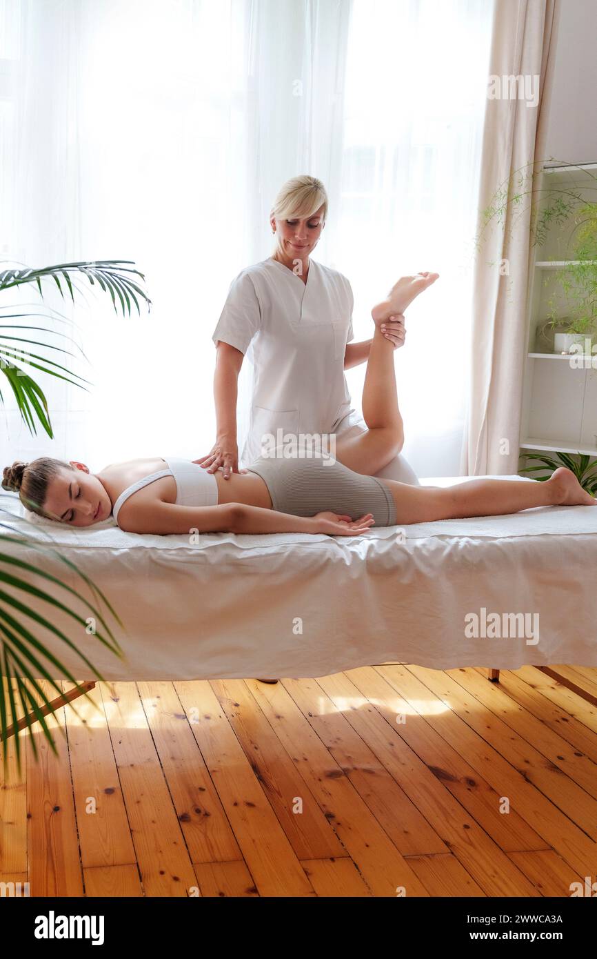 Chiropractor massaging patient in treatment room Stock Photo