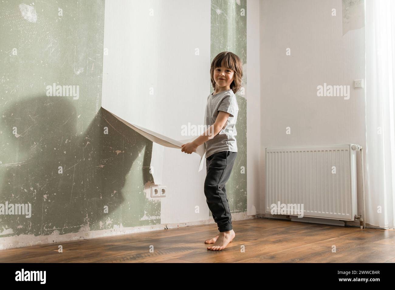 Boy peeling old wallpaper from wall at home Stock Photo Alamy