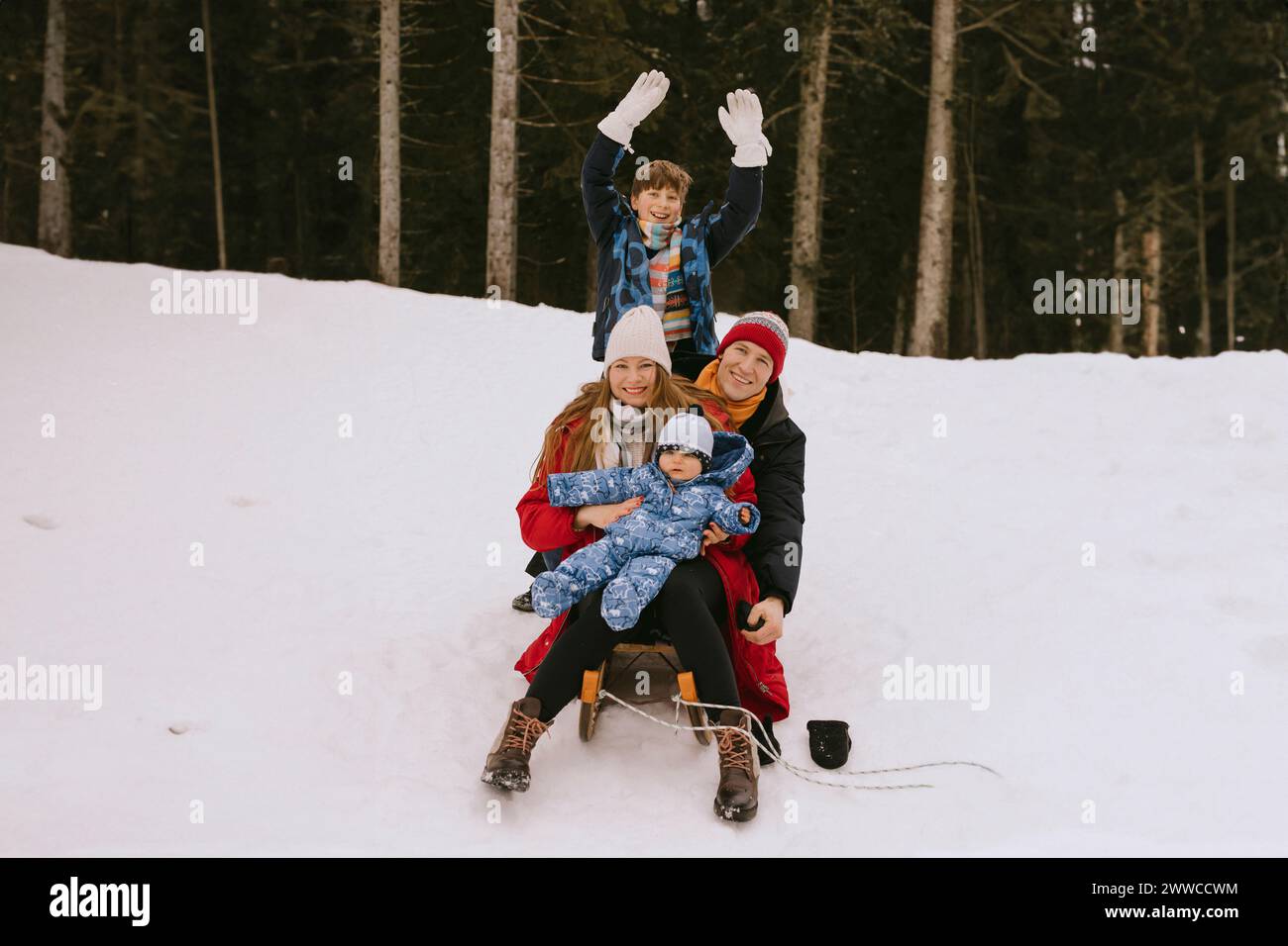 Happy family having fun in winter forest Stock Photo