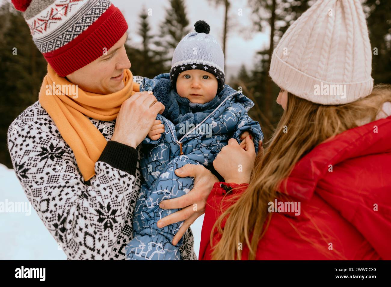 Cute baby boy with parents in winter forest Stock Photo