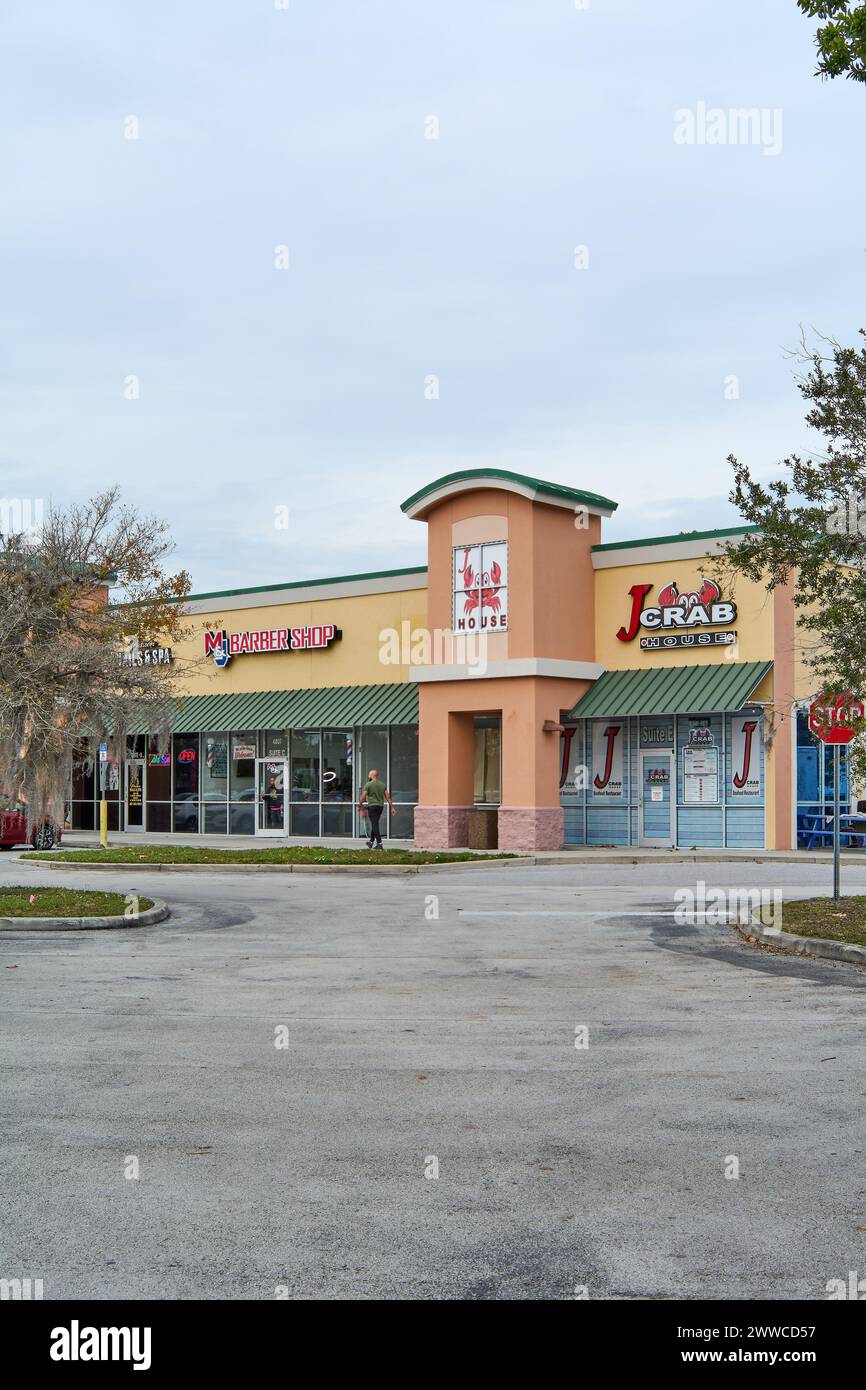 Florida, USA - March 23, 2024: Colorful image showing a barbershop next to a seafood restaurant, both with vibrant signs, inviting potential customers Stock Photo