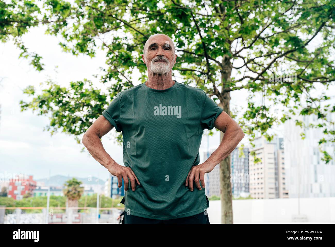 Active senior man standing with arms akimbo Stock Photo - Alamy
