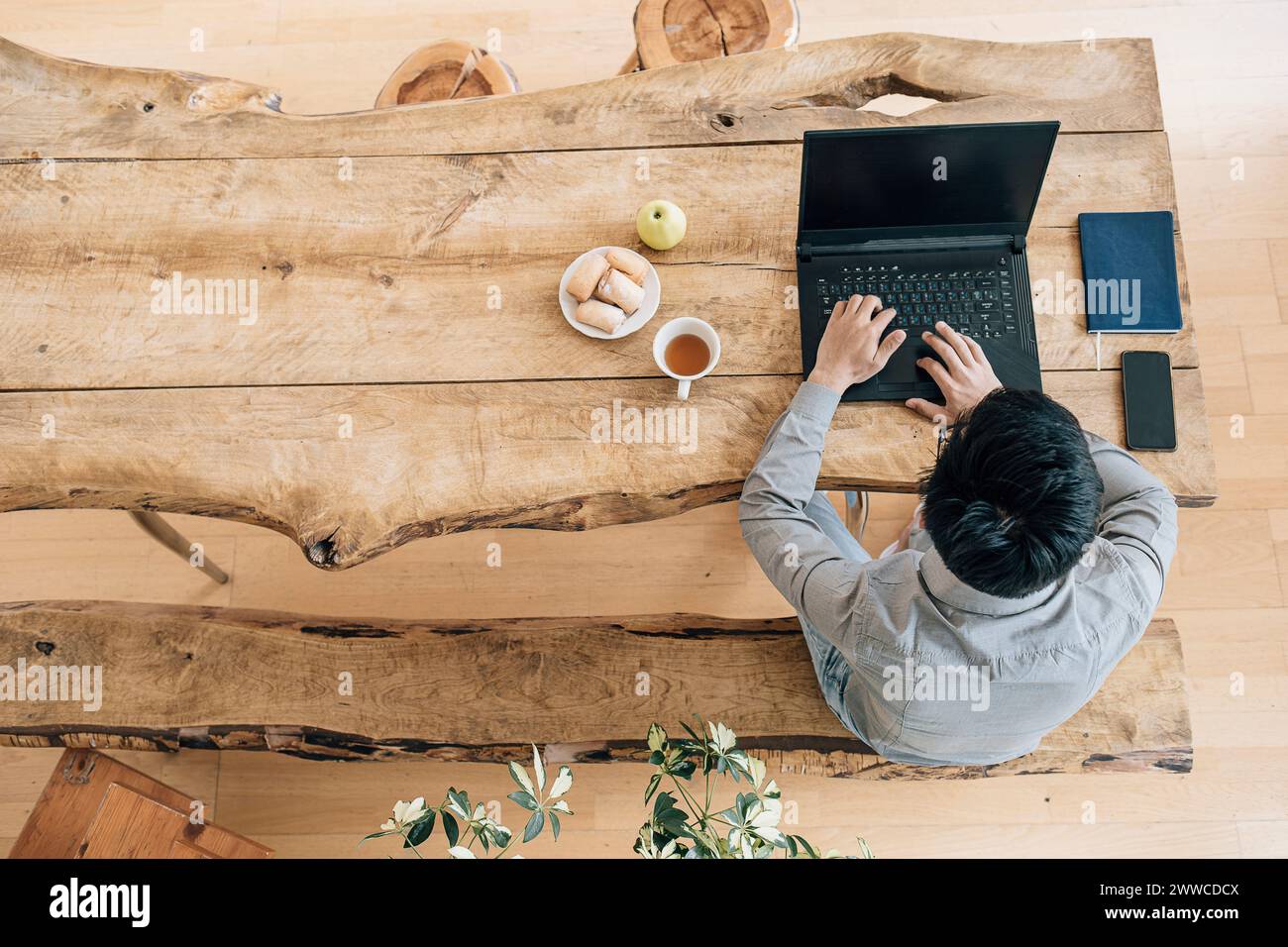 Young IT technician using laptop at table working in creative office Stock Photo