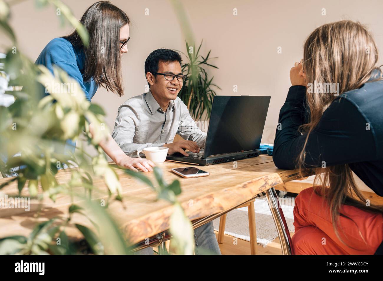 Smiling IT technician discussing with colleagues at creative office Stock Photo