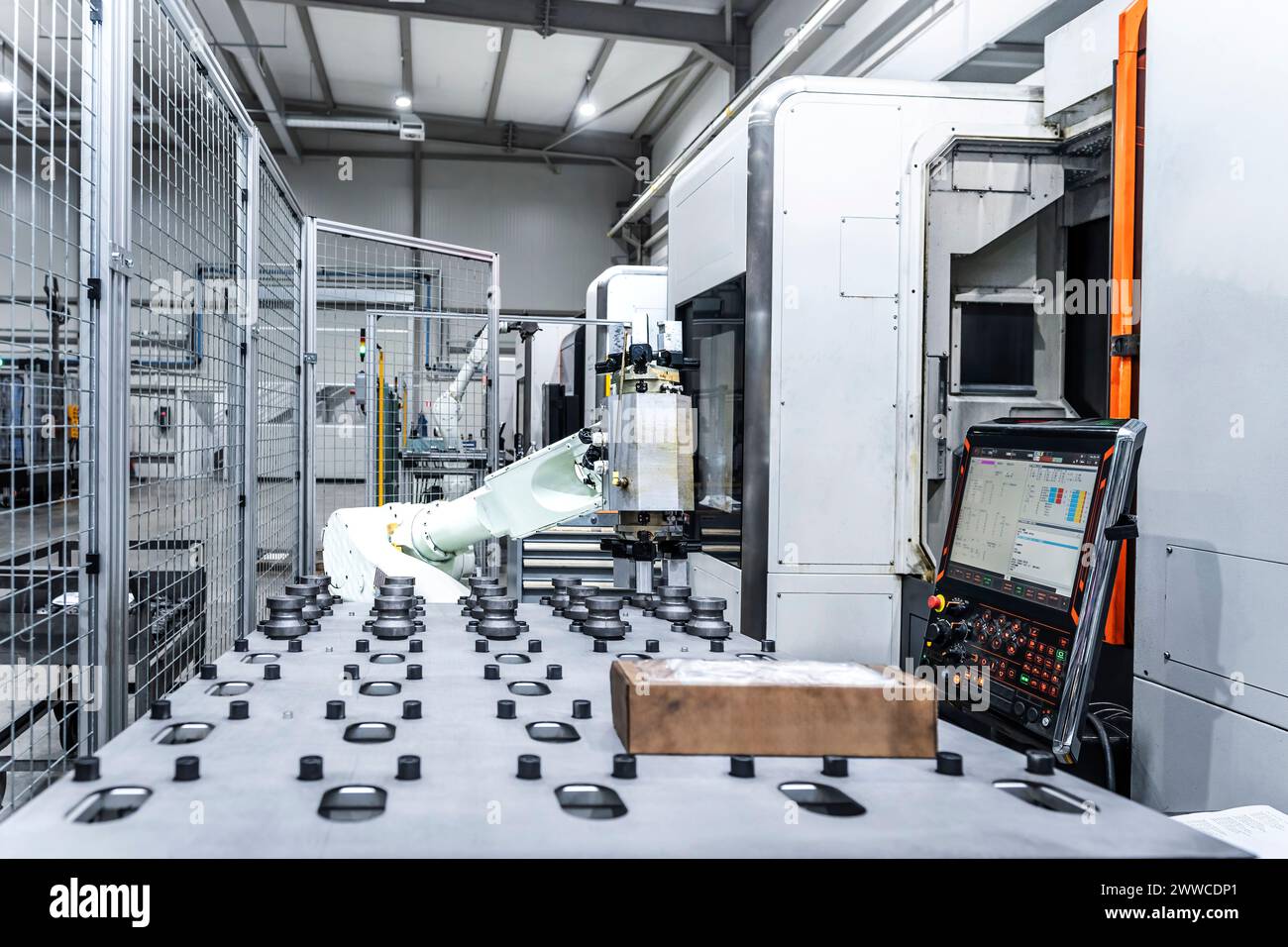 White robotic arm with CNC machinery in modern factory Stock Photo - Alamy