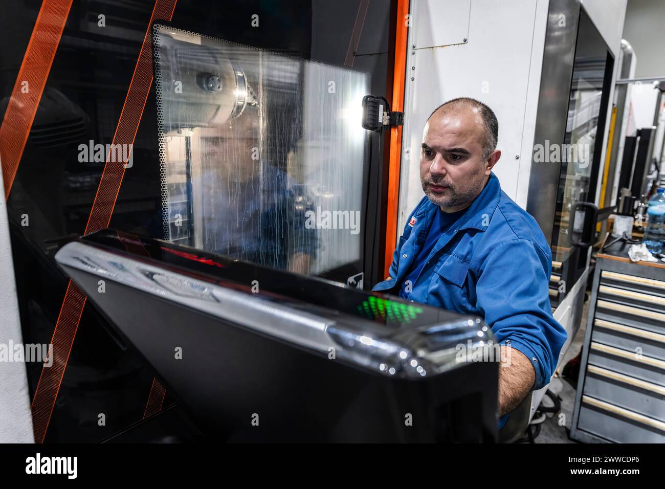 Maintenance engineer operating robotic CNC machinery in manufacturing factory Stock Photo