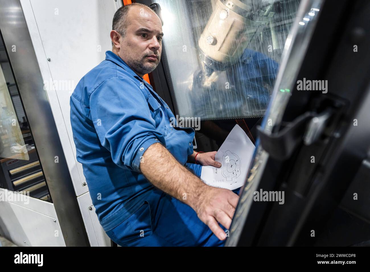 Technician operating machinery in industry Stock Photo