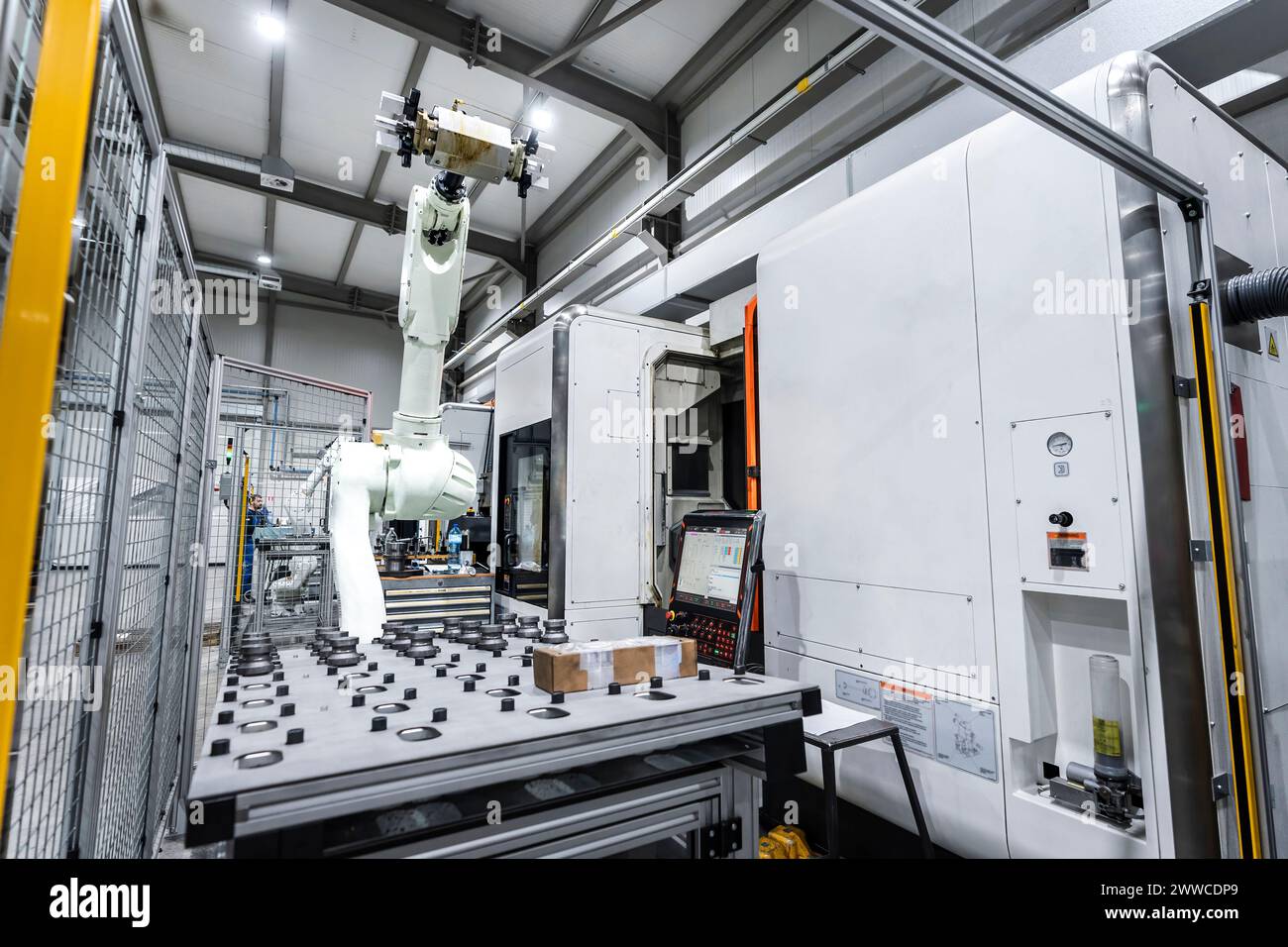 Robotic arm with white machinery in factory Stock Photo