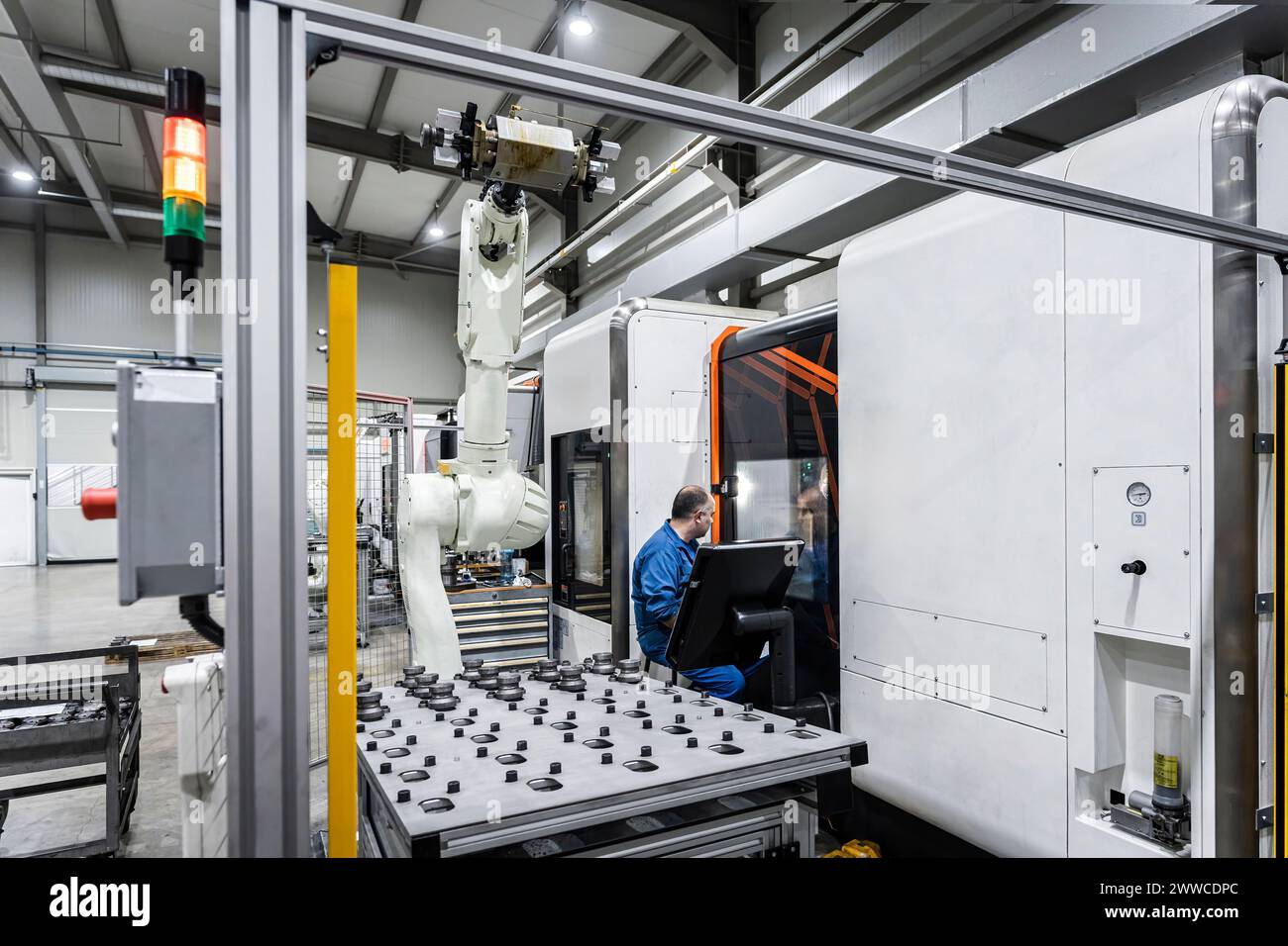 Maintenance engineer operating robotic CNC machinery in modern manufacturing factory Stock Photo