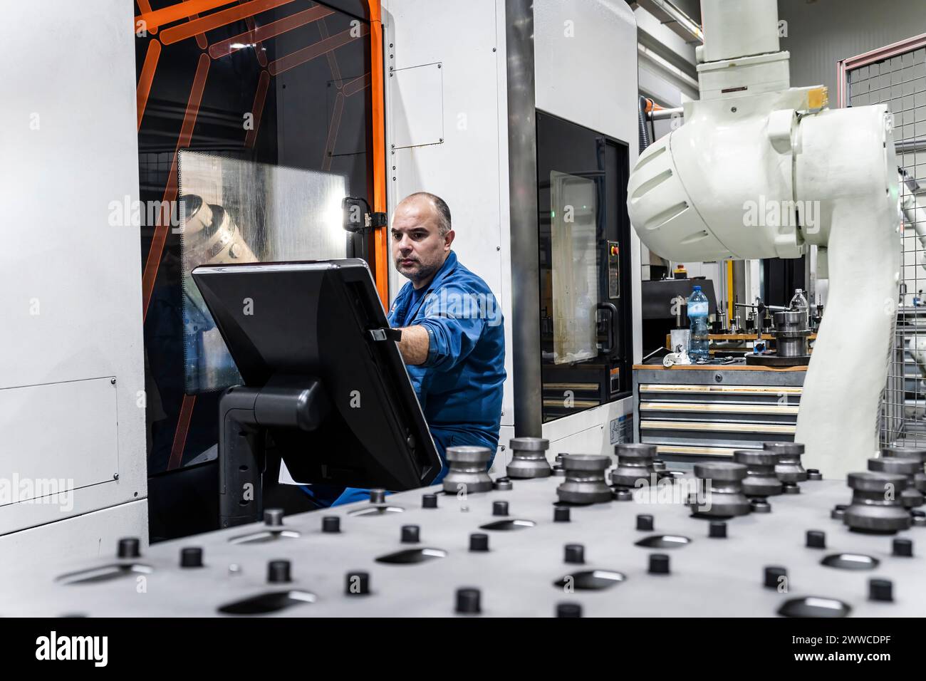 Engineer operating robotic machinery in modern manufacturing factory Stock Photo