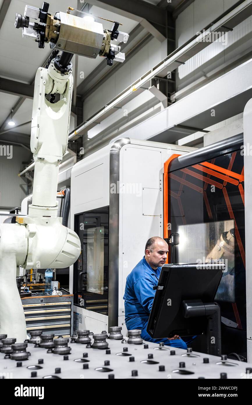 Engineer operating robotic machinery in modern factory Stock Photo