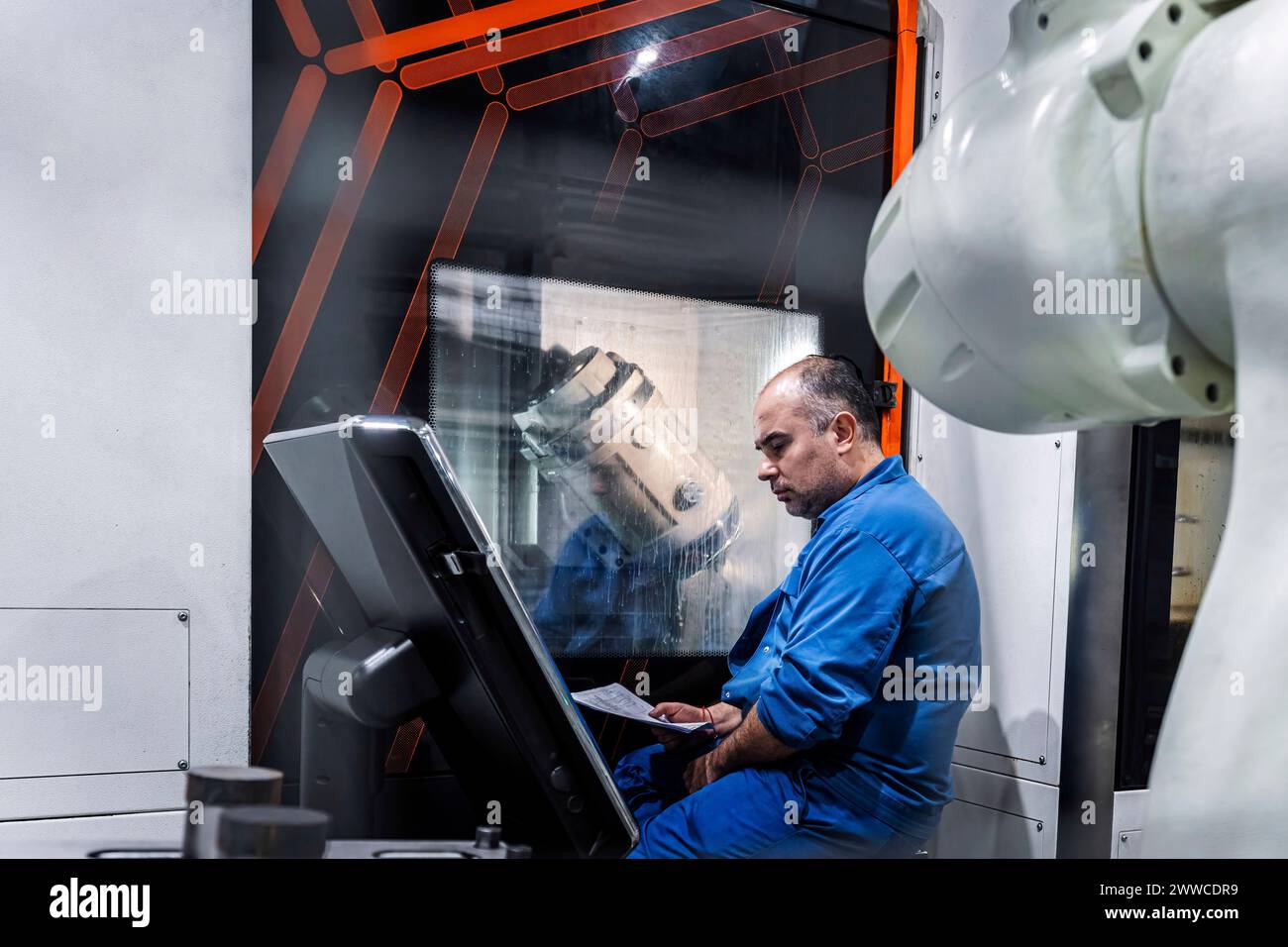 Technician operating CNC machine in industry Stock Photo