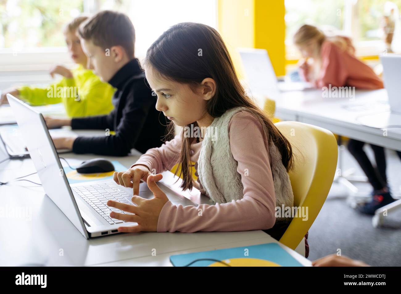 Girl using laptop for programming in classroom Stock Photo