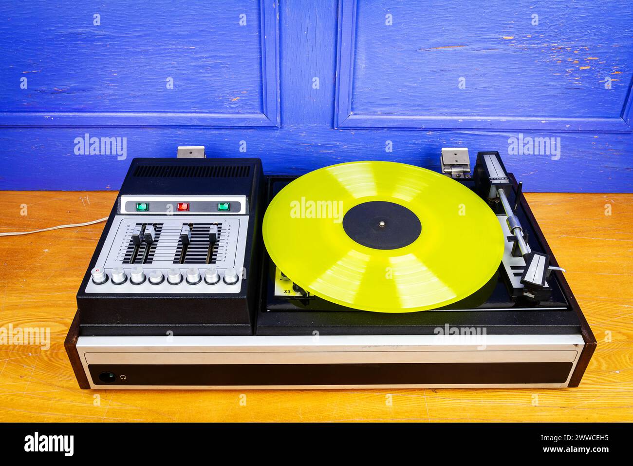 Vintage turntable vinyl record player with yellow vinyl on a table ...
