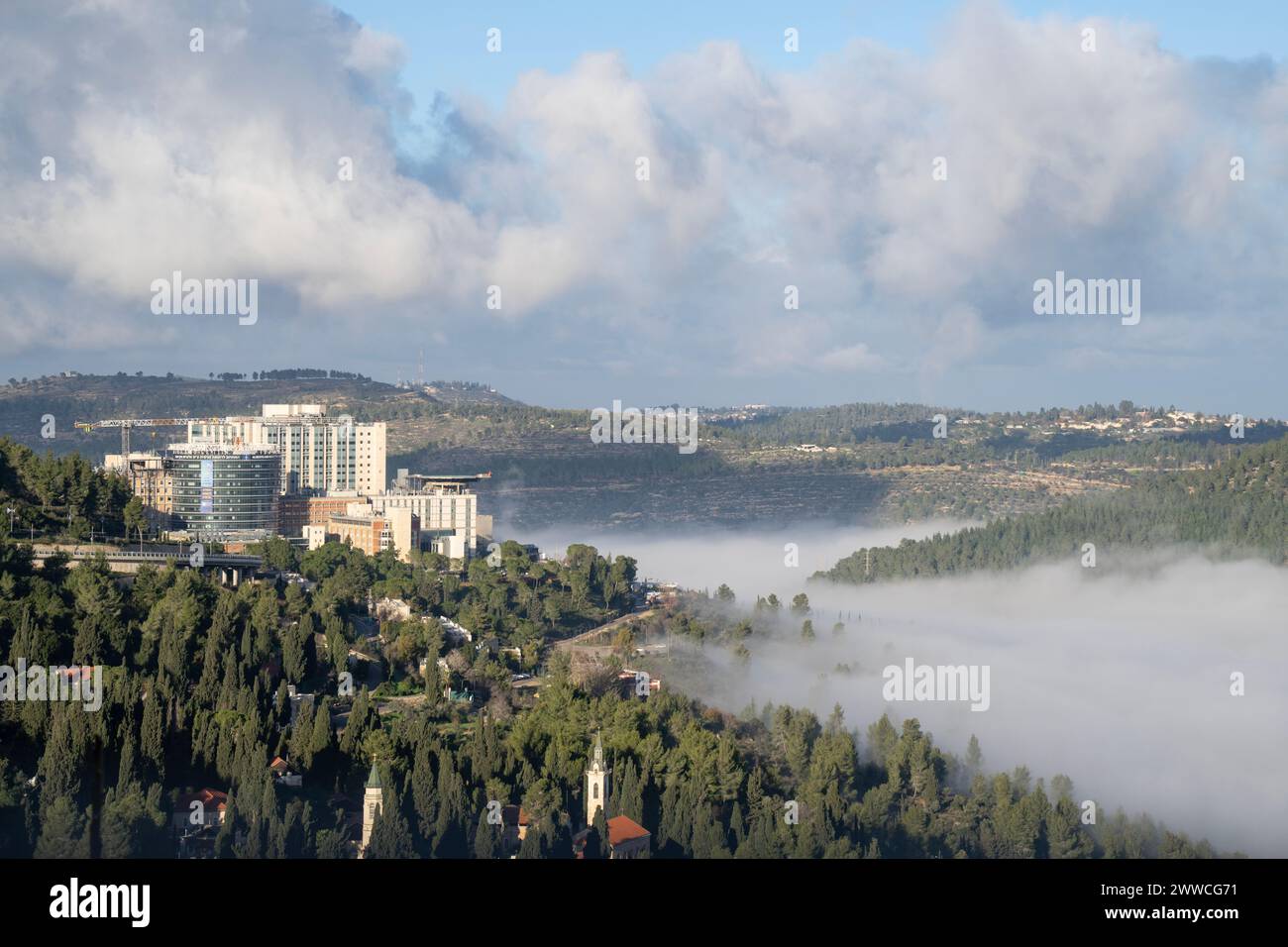Jerusalem, Israel - January 5th, 2024: A cloud in a valley among the Judea mountains, below the Hadassah hospital, Jerusalem, Israel. Stock Photo