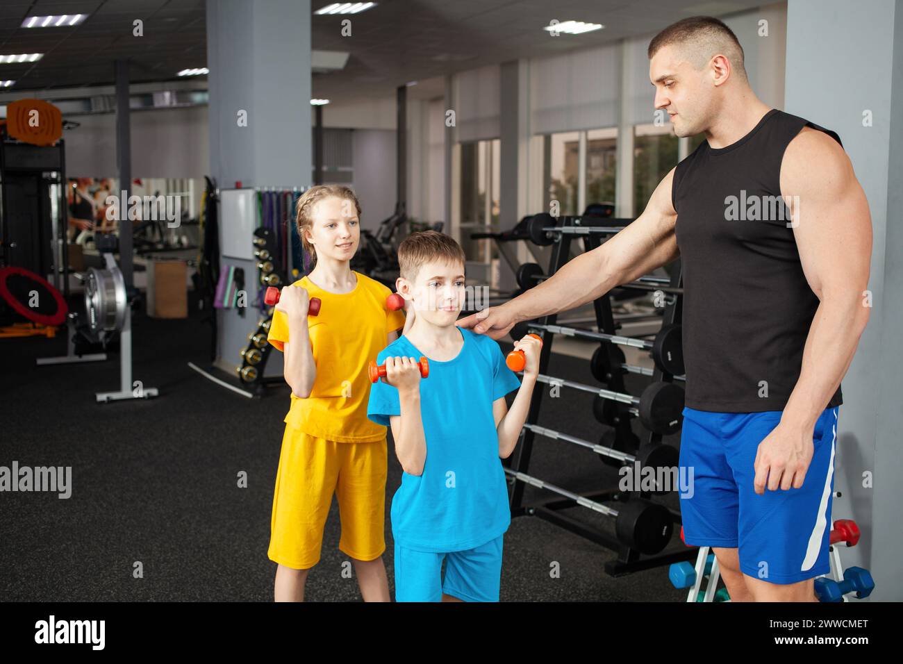 Happy children perform physical exercises in gym with a coach Stock ...