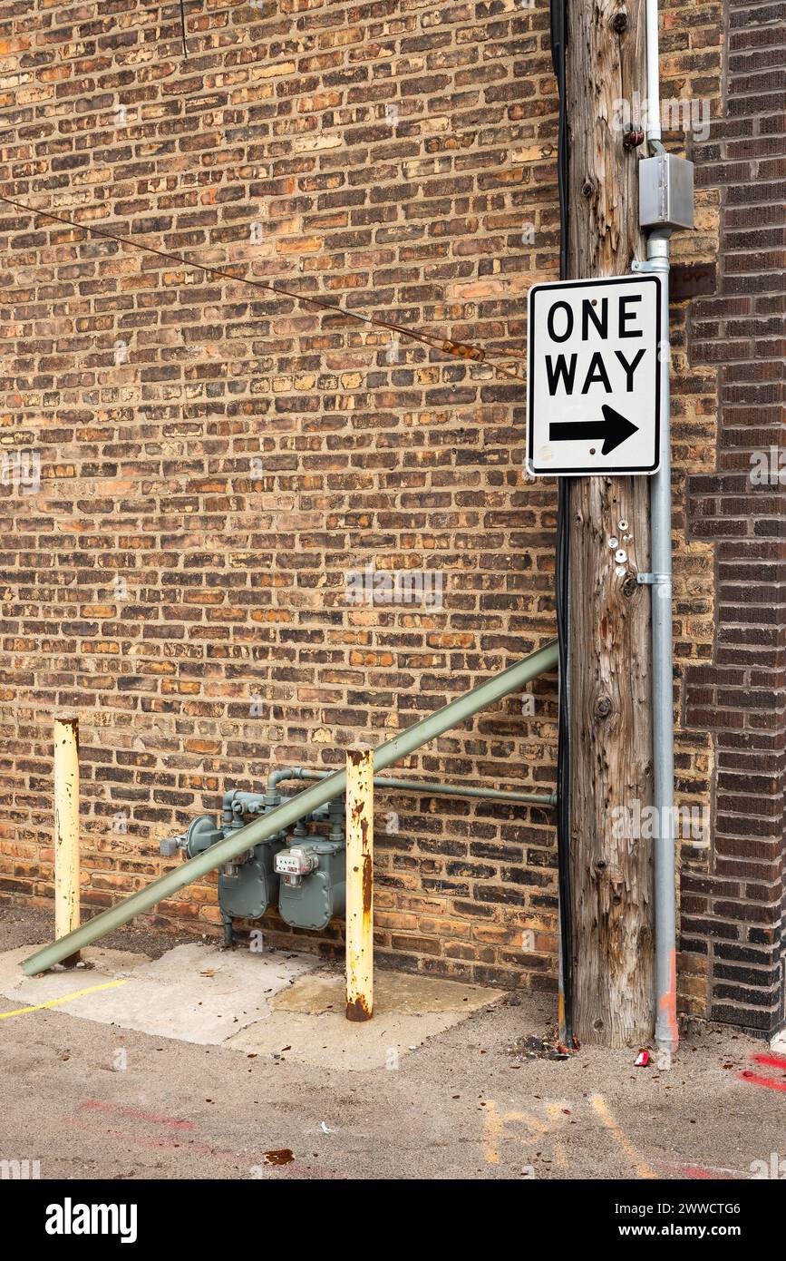 One way sign and brick wall in back alley. Stock Photo