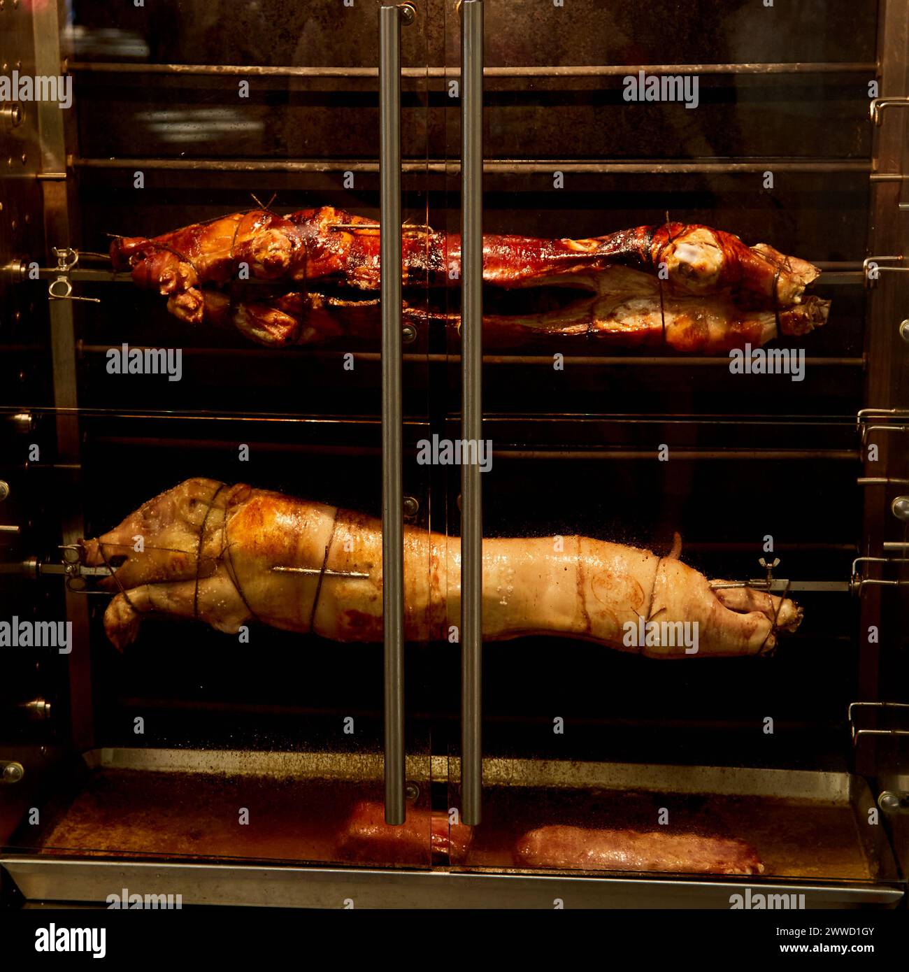 Roasting Suckling Pigs on Spit at a Parisian Market Stock Photo