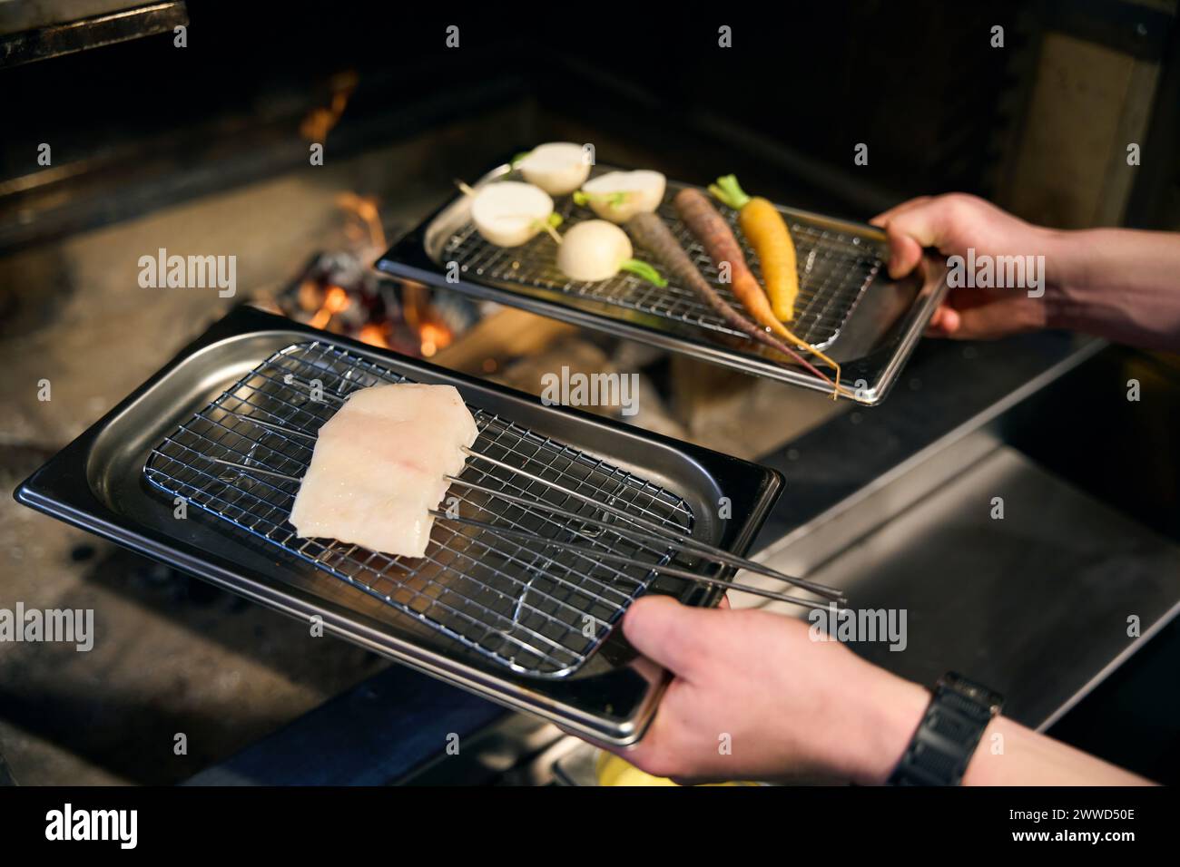 Net Tray Jpg Pike fillet with vegetables on iron net tray in hands of cropped male ...