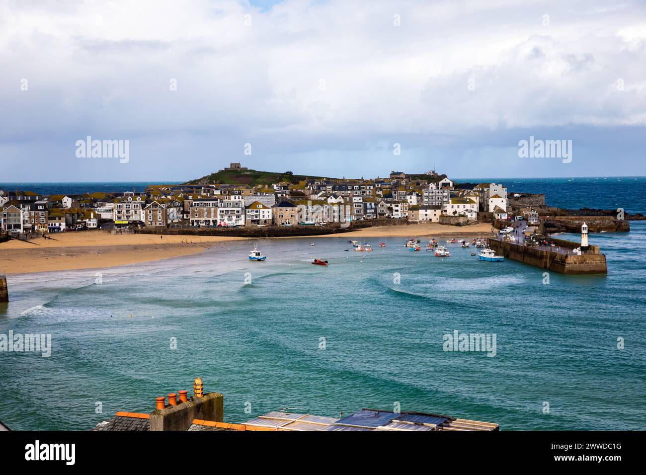 St Ives, Cornwall, 23rd March 2024, People were out enjoying the glorious spring sunshine between the rain showers in St Ives, Cornwall. The temperature was a chilly 9C but with strong winds it felt much cooler. The forecast is for light cloud and moderate breeze for tomorrow. Credit: Keith Larby/Alamy Live News Stock Photo