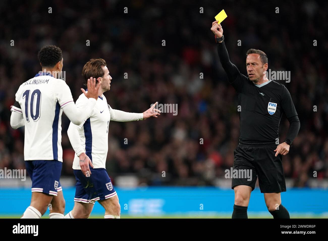 England's Jude Bellingham (left) is shown a yellow card by Match referee Artur Manuel Soares Dias (right) during the international friendly match at Wembley Stadium, London. Picture date: Saturday March 23, 2024. Stock Photo