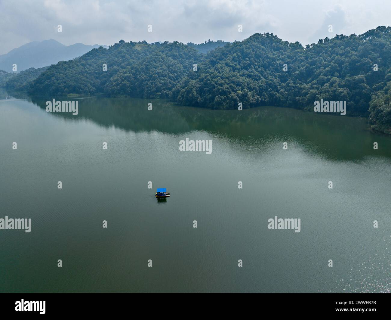 Aerial view of Begnas Lake the third largest lake of Nepal. Wild nature and trees with houses surround the lake, typical Nepalese boats in the water Stock Photo