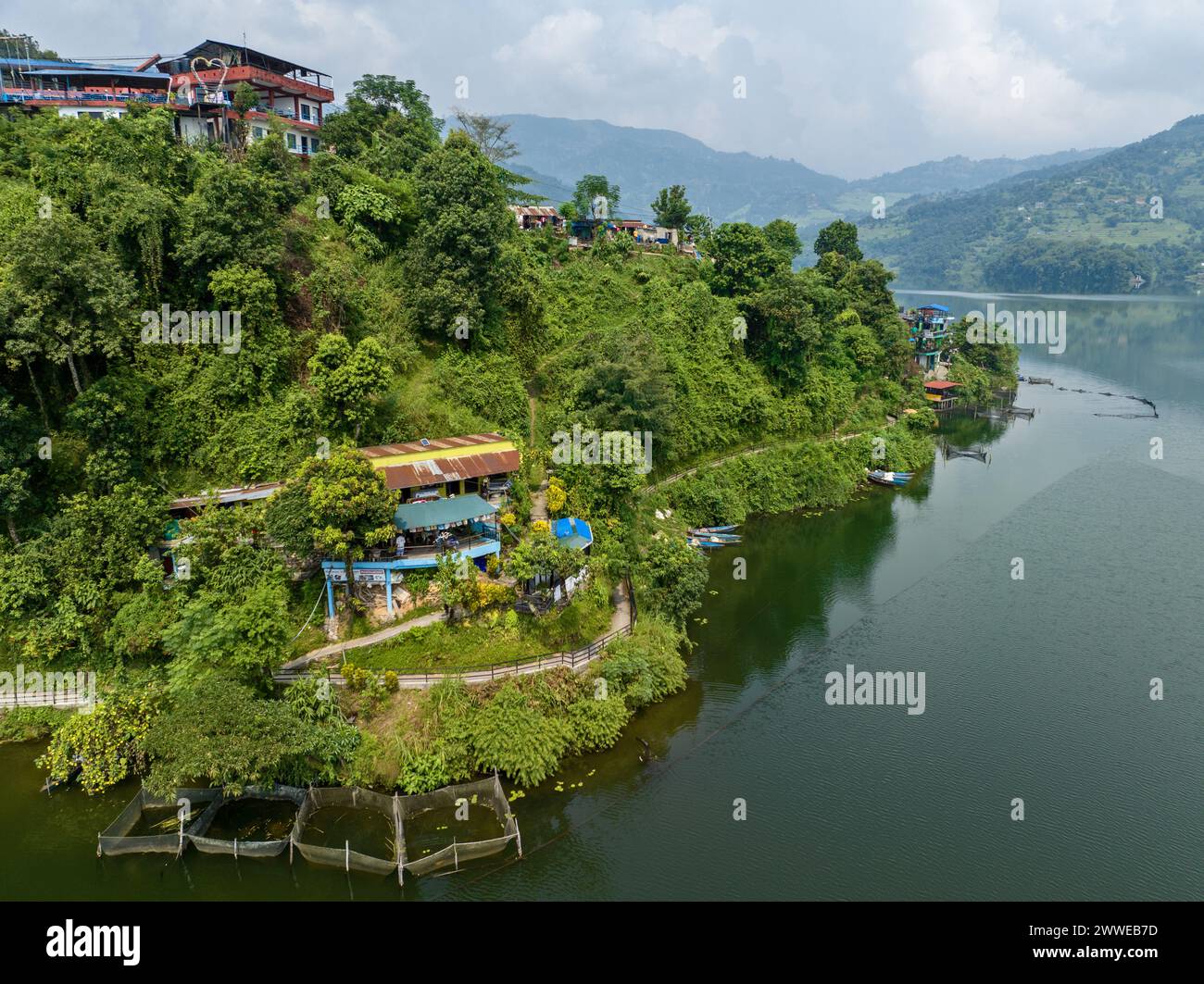 Aerial view of Begnas Lake the third largest lake of Nepal. Wild nature and trees with houses surround the lake, typical Nepalese boats in the water Stock Photo