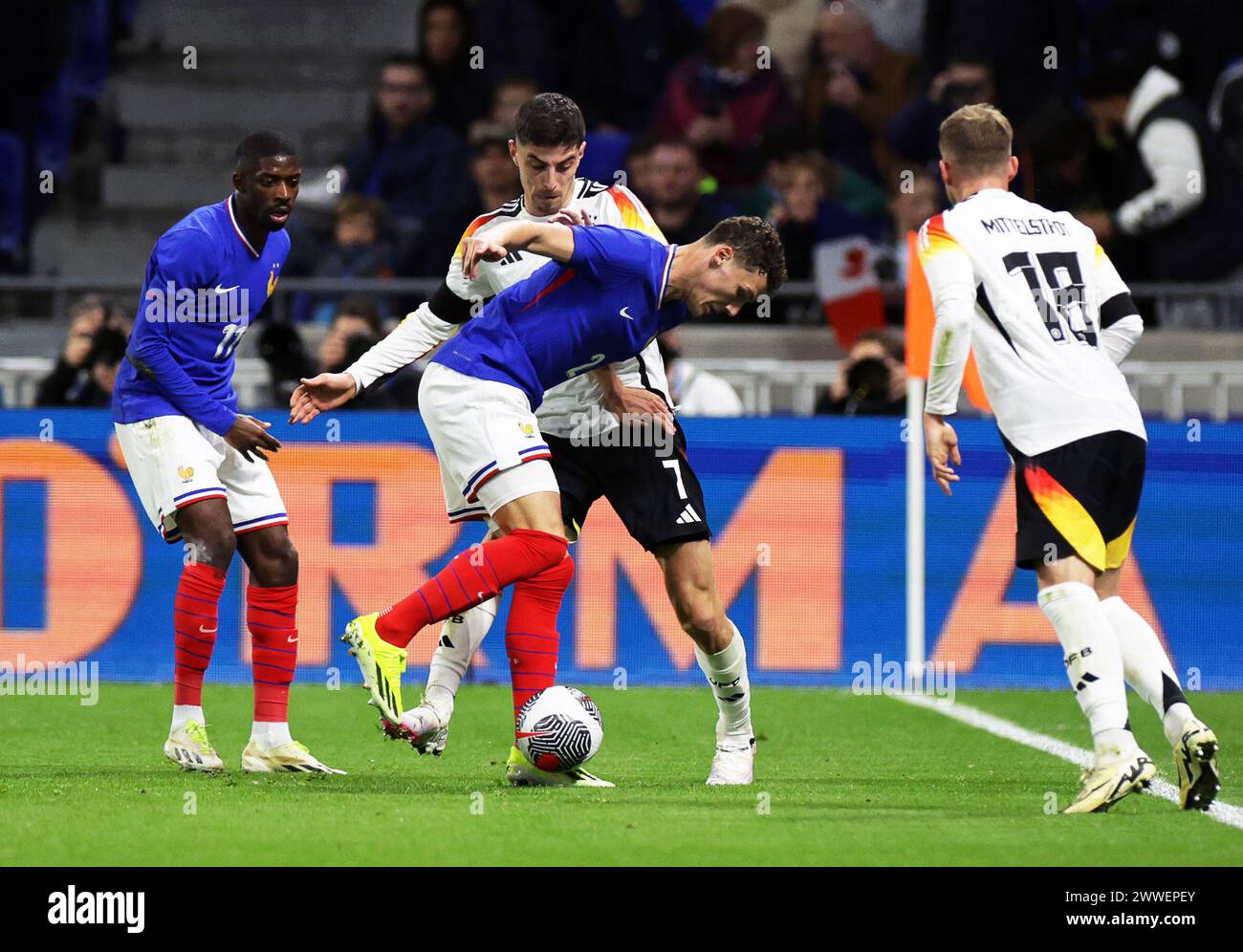 Lyon, France. 23rd Mar, 2024. Soccer: International match, France - Germany, Groupama Stadium. Germany's Kai Havertz (center back) and Maximilian Mittelstädt (right) in action against France's Ousmane Dembelé (left) and Benjamin Pavard. Credit: Christian Charisius/dpa/Alamy Live News Stock Photo