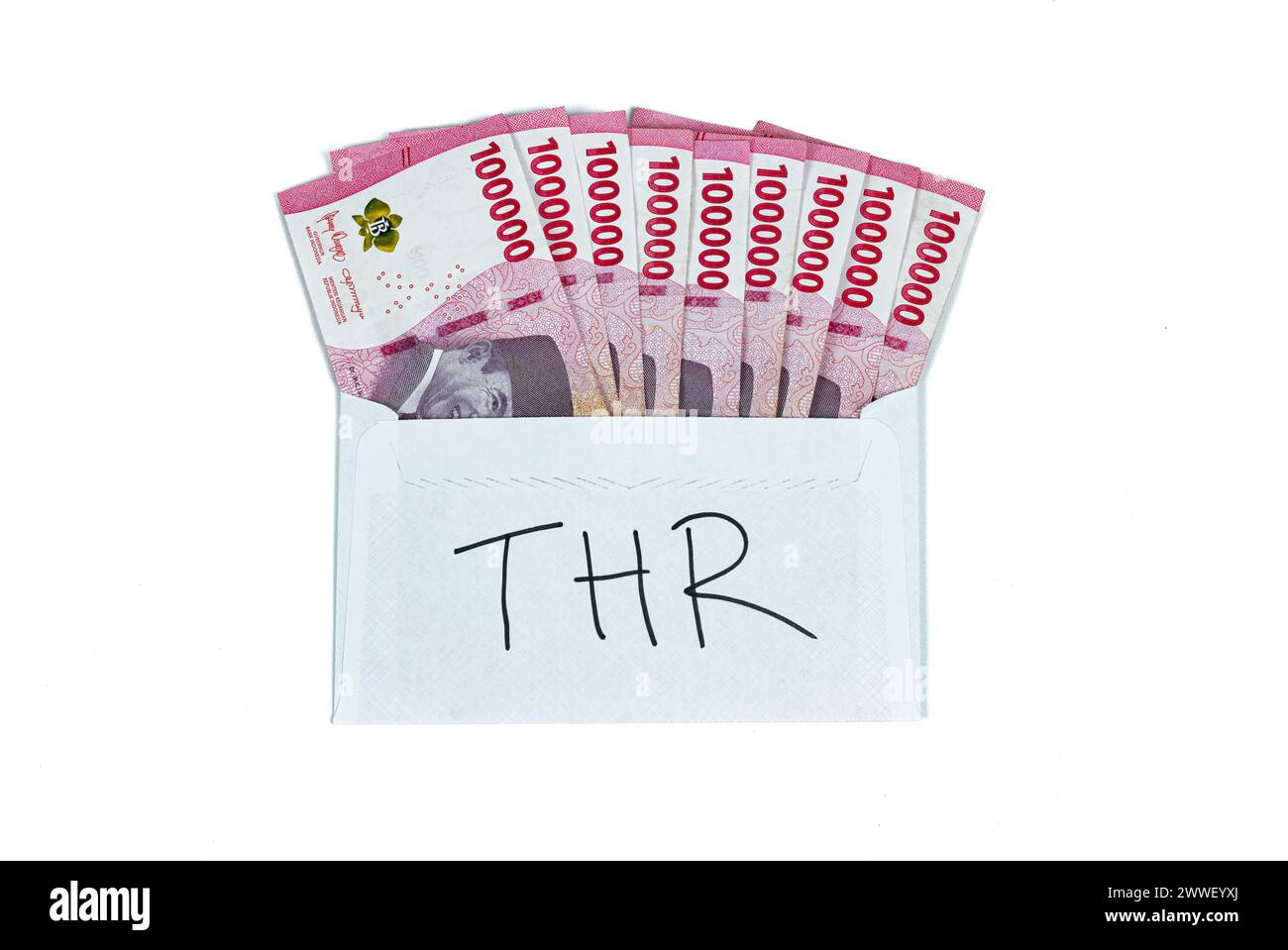 Indonesian rupiah currency. White envelope with THR Text containing stack of IDR 100,000 cash.THR is holiday allowance on Eid al-Fitr or Lebaran days. Stock Photo